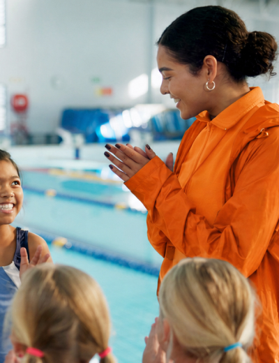 Swim coach clapping encouraging kids