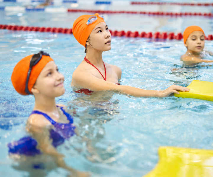 Swimming instructor teaching children in a pool